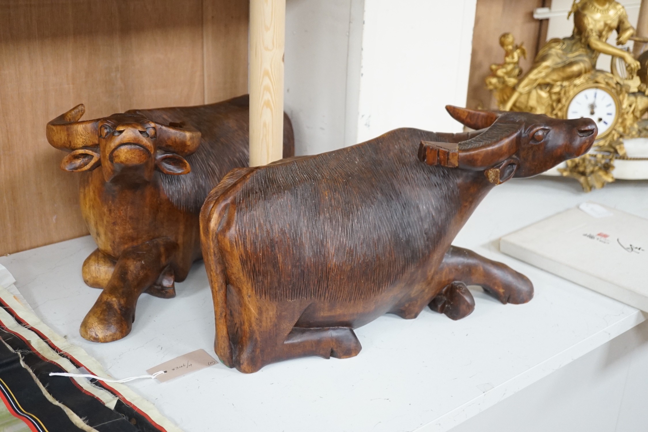 A pair of South East Asian carved wood figures of water buffalo, 43cm long